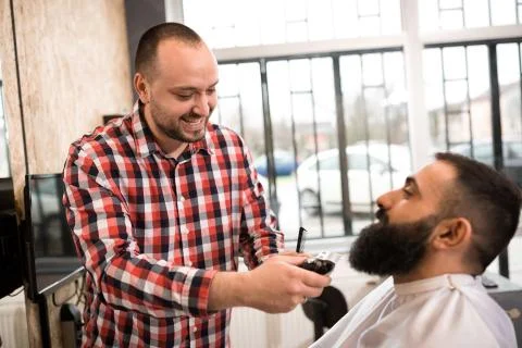 Barber cutting a beard with scissors Stock Photos