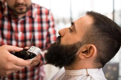 Barber cutting a beard with scissors Foto stock