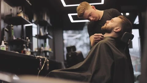 Barber Cutting Client Hair in Modern Barbershop Stock Footage 332639064
