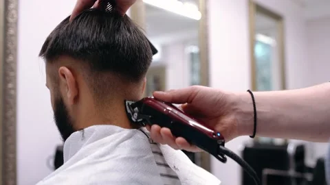 Barber cutting hair with scissors. back view of man in barber shop Vídeo Stock 144575697
