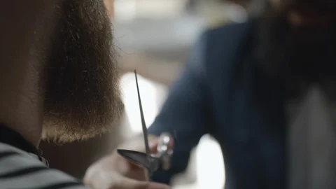 Barber cutting man's red beard with scissors in slow motion Stock Footage 117713854