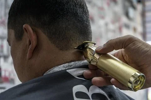 A barber cutting a shape in back of neck Fotos Stock