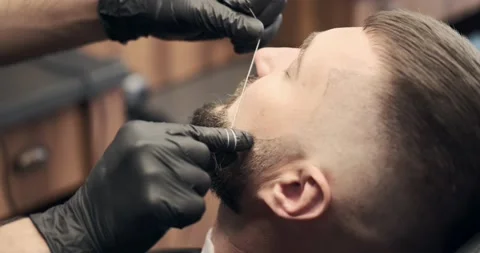 Barber doing threading procedure on face Stock Footage 158815133