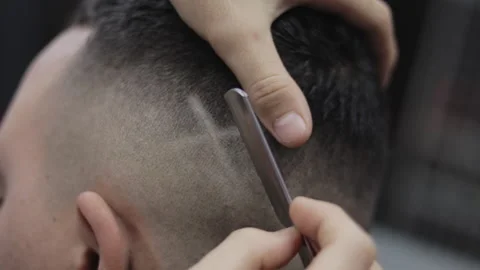 Barber draws an X on client with a razor Video stock 147460147