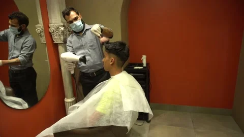 Barber drying hairs while wearing mask and gloves salon, Covid 19 Corona safety. Video stock 130207981
