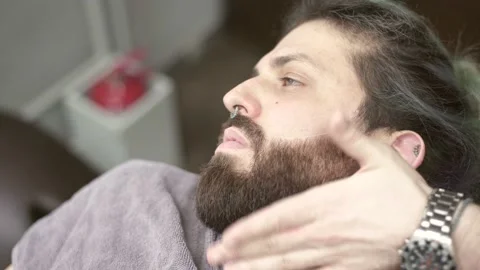 Barber hands with a razor shaving beard of customer Stock Footage 132054508