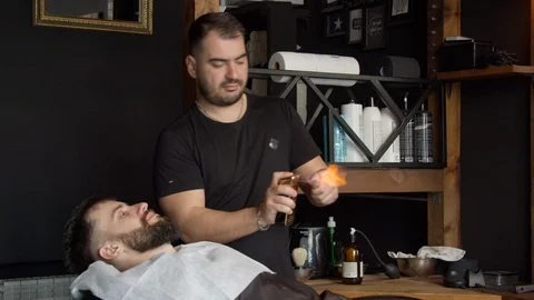 Barber heating razor before shaving Stock Footage 127187046
