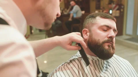 Barber makes the cut or styling of a beard Stock-Footage 100637084