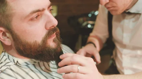 Barber makes the cut or styling of a beard Stock-Footage 100637380