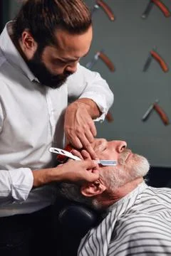 Barber making old man look cool and fashion Stock Photos