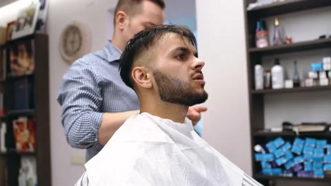 Barber master arranges a client's beard, bearded man, massages the skin of the Stock Footage 144452991