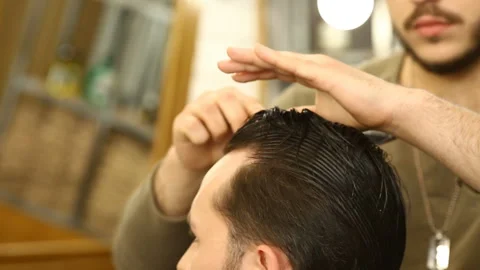 Barber master combing and modelling wet hair of client Stock Footage 91215676