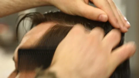 Barber master smoothing and combing hair of client Stock Footage 91215591
