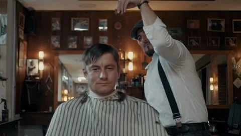 Barber mimics "Salt Bae" while cutting a client. Stock Footage 132284787