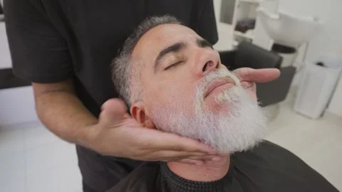 Barber performing beard massage with moisture cream after dyeing process.MOV Stock Footage 255795959