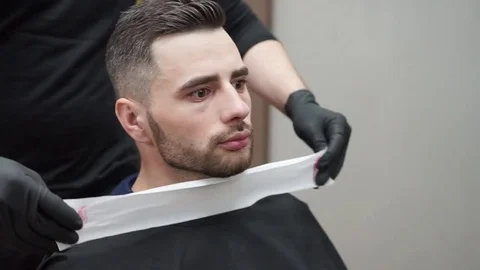 Barber prepares the client for a haircut. Stock Footage 81826537