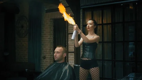 The barber prepares to cut a man with fire and lights a fire over his head Stock Footage 101741254