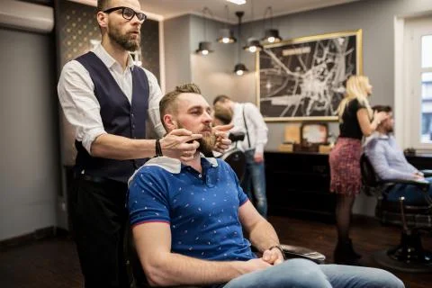 Barber preparing customer for shaving Stock Photos