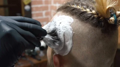 Barber preparing his client for a haircut in a modern barber shop Stock Footage 86686234