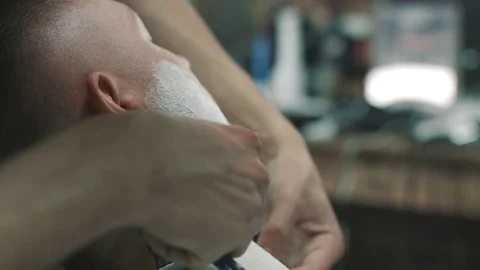 Barber shaves the beard of the client. Vídeos de archivo 80024965