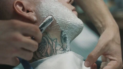 Barber shaves the beard of the client. 動画素材 80025014