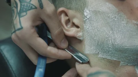 Barber shaves the beard of the client. Vídeo Stock 80029245