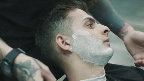 Barber shaves the beard of the client. Stock Footage 80029350