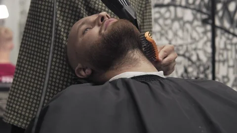 Barber shaving beard with electric razor in male salon. Shaving bearded man Stock Footage 104771479