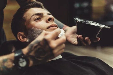 Barber shaving client Stock Photos