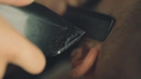 Barber shaving a client's beard with electrical shaving machine, close up Video stock 67315809