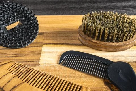 Barber shop flatlay, with different combs and brushes on a wooden table. Stock Photos