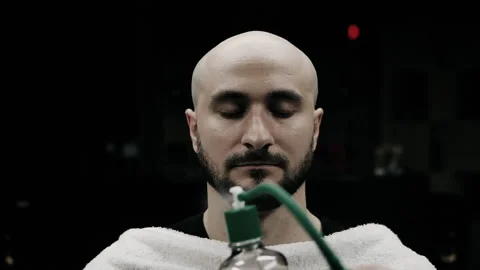 Barber spraying aftershave on beard of a customer Stock Footage 150272015