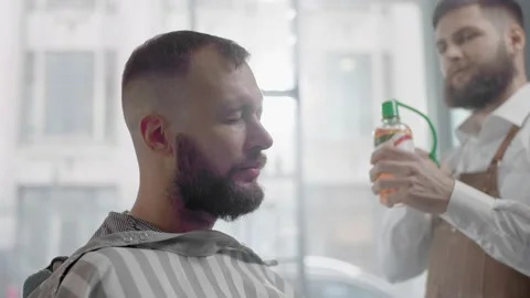Barber Sprays Perfume on a Client New Haircut. Stockbeeldmateriaal 136543572