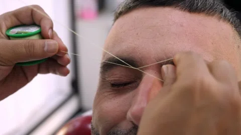 Barber threading eyebrows with Arabic beauty method Stock Footage 318134970