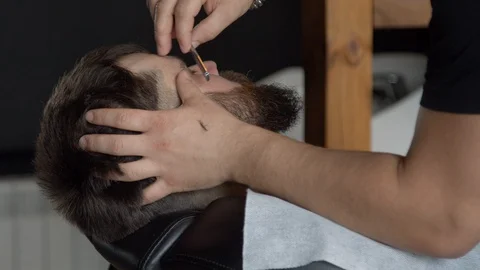 Barber trimming beard of client Stock Footage 127173772