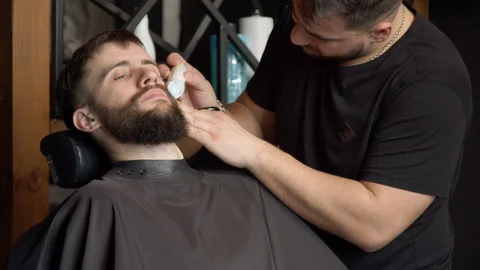 Barber trimming beard of client Stock Footage 127173925