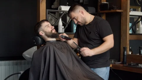 Barber trimming beard of client Video stock 127183837