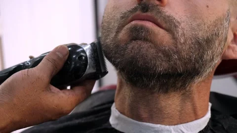 Barber trimming beard with clipper on young man precise grooming 库存影片 333195751
