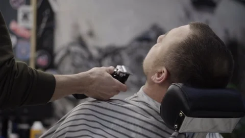 Barber trimming beard to his client Stock Footage 88438384