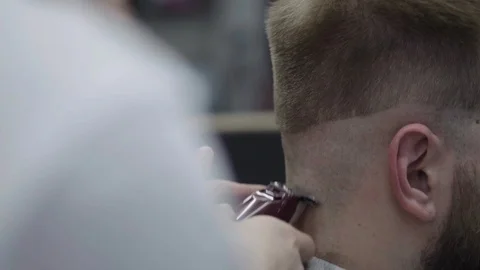 Barber trimming beard to his client Stock Footage 88438528
