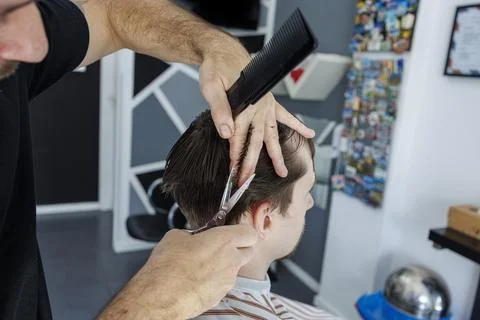 Barber Trimming Side of Client Head With Scissors and Comb Close Up Stock Photos