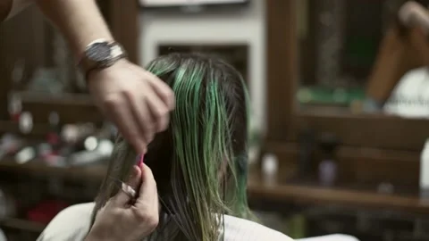 Barber using a comb while providing a haircut for man with long hair Stock Footage 132054301