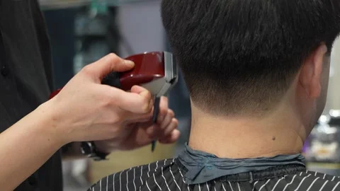 Barber Using Electric Clippers to Trim Back of Man's Hair in Salon Stock-Footage 344782816