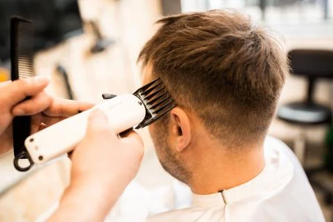 Barber using grooming machine to making haircut to client Stock Photos