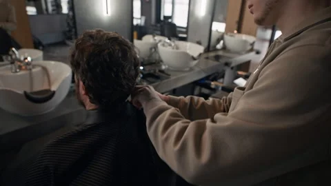 Barber Using Haircutting Cape, Putting It On Man Stock Footage 330408012