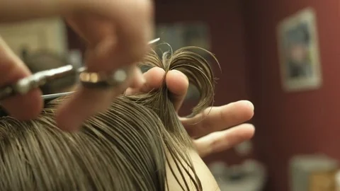 Barber using a scissors to cut a mans hair. Close up Video stock 76966722