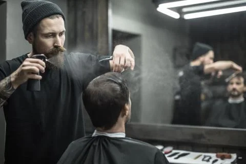 Barber is using spray bottle 스톡 사진