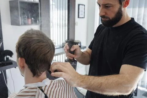 Barber Using Spray Bottle While Styling Client Hair in Contemporary Barbersho Stock Photos