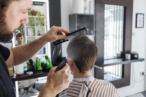Barber Using Spray Bottle While Styling Client Hair in Contemporary Barbersho Stock Photos