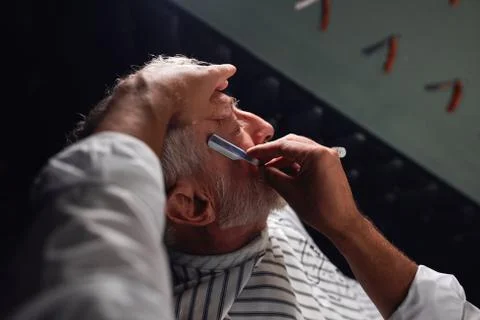 Barber using straight razor during work Stock Photos